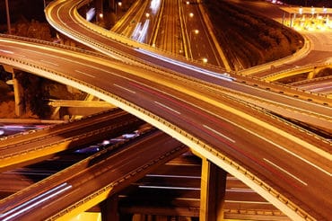 Cars drive quickly in a blur on a highway spaghetti junction