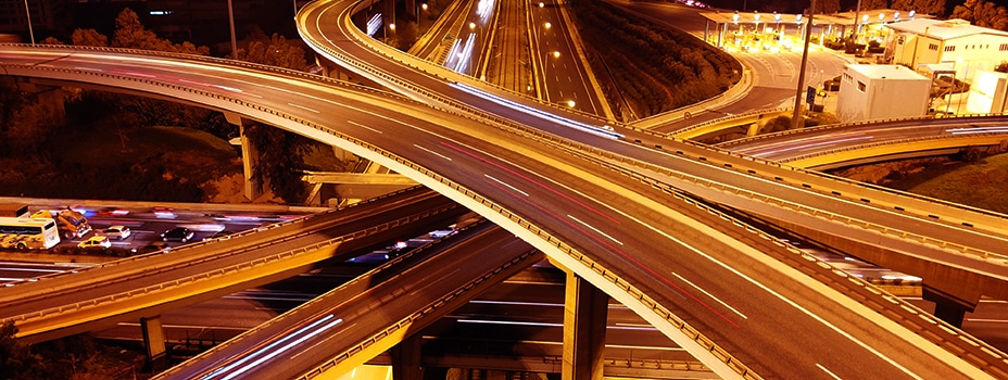 Cars drive quickly in a blur on a highway spaghetti junction